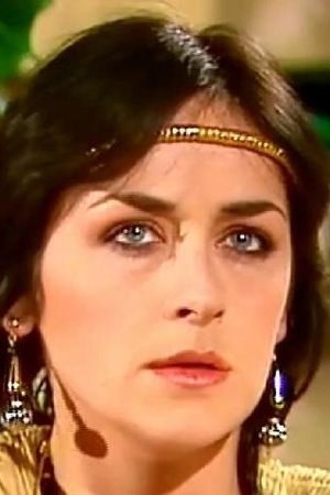 Studio portrait of Cathy Ménard with a gold headband and drop earrings, 1980s